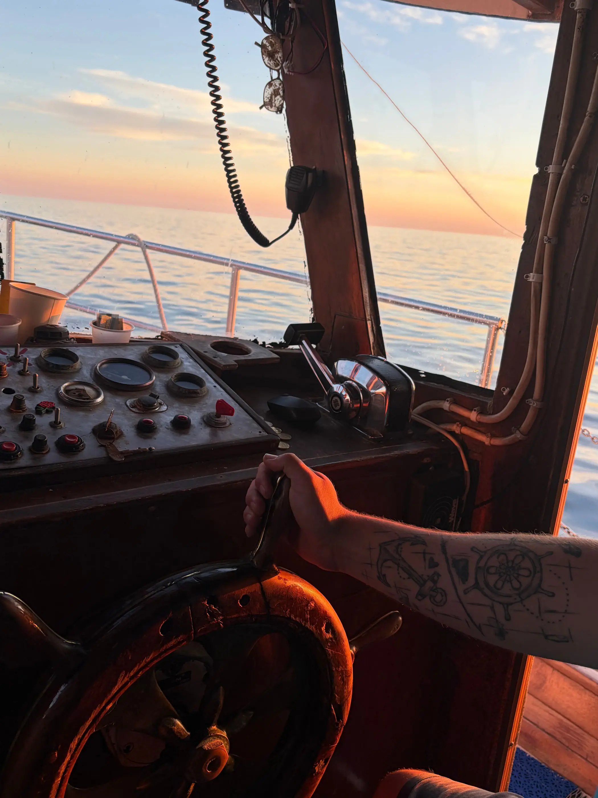 View from the helm of a traditional wooden boat at sunset off Rovinj