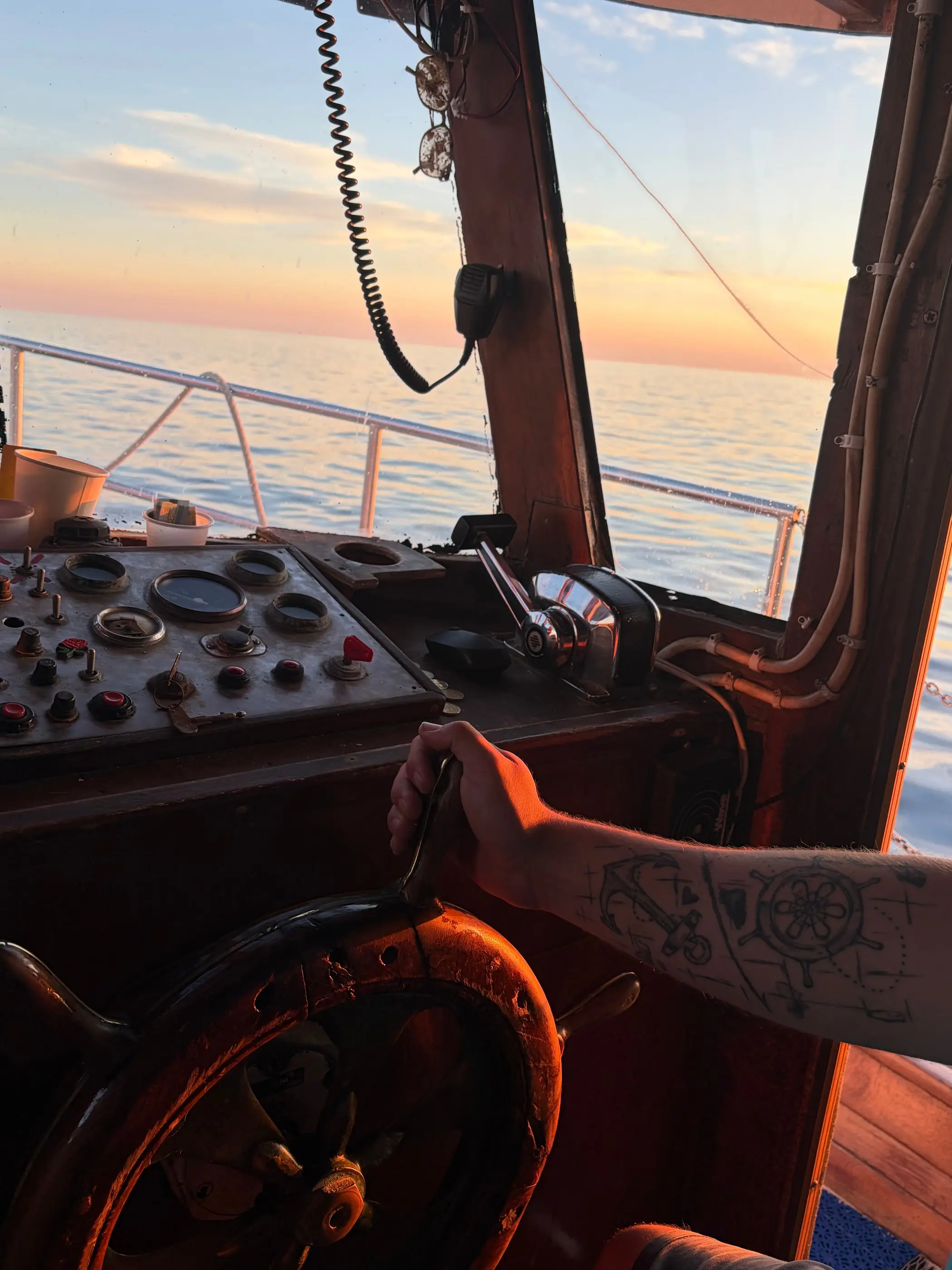 View from the helm of a traditional wooden boat at sunset off Rovinj